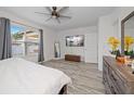 Bright main bedroom boasts a ceiling fan, TV, bench, and sleek, modern wood flooring at 9647 Summers Cay Cir, Thonotosassa, FL 33592