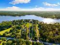 Expansive aerial view reveals the property's generous land and lake access, surrounded by lush greenery and serene waters at 18258 Wayne Rd, Odessa, FL 33556