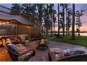 Cozy outdoor patio featuring a fire pit and comfortable seating, perfect for enjoying serene lake views and tranquil evenings at 18258 Wayne Rd, Odessa, FL 33556