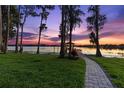 Picturesque backyard with a charming stone path leading to a private dock on the serene lake, perfect for relaxation at 18258 Wayne Rd, Odessa, FL 33556