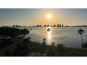 Beautiful sunrise over the bay, with the community swimming pool and palm trees in the foreground at 100 Oakmont Ln # 802, Belleair, FL 33756