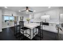 Modern kitchen with dark floors, an island with seating, and stainless steel appliances at 100 Oakmont Ln # 802, Belleair, FL 33756