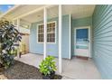 Inviting front porch with blue siding and white columns, offering a cozy entrance to the home at 105 1St Se Ave, Lutz, FL 33549
