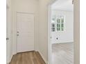 Hallway featuring light, modern flooring and white doors, with a glimpse of a windowed room at 105 1St Se Ave, Lutz, FL 33549