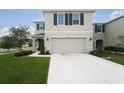 Inviting two-story home featuring a spacious driveway and attached two-car garage at 10826 Trailing Vine Dr, Tampa, FL 33610