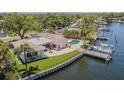 Waterfront property featuring a backyard pool, boat dock, well-maintained lawn, and a patio area at 1185 36Th Ne Ave, St Petersburg, FL 33704