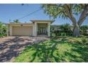 Charming single-story home with a brick driveway, lush landscaping, and a welcoming entryway at 1185 36Th Ne Ave, St Petersburg, FL 33704