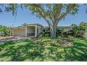 Inviting single-story home with a brick driveway, well-manicured lawn, and mature shade tree at 1185 36Th Ne Ave, St Petersburg, FL 33704