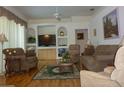 Comfortable living room featuring hardwood floors, plush sofas and a ceiling fan at 12271 Centralia Rd, Weeki Wachee, FL 34614