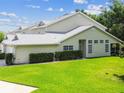 Attractive exterior view showcasing a well-manicured lawn, tidy hedges, and a pleasant screened-in porch at 1624 Lullwater Ln, Lutz, FL 33549