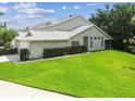 Charming home boasts a well-kept lawn, trimmed hedges, and an inviting screened-in porch for outdoor enjoyment at 1624 Lullwater Ln, Lutz, FL 33549