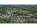 Birds-eye view of a neighborhood showcasing the proximity to schools, lakes, and a sprawling wooded area at 16367 Ashington Park Dr, Tampa, FL 33647