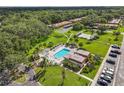 Aerial view of community pool with lounge area, lush landscaping, and well-maintained grounds at 1701 Pinehurst Rd # 9G, Dunedin, FL 34698