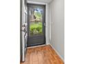 Open front door, wood-look tile foyer and a view of the lush greenery outside at 1701 Pinehurst Rd # 9G, Dunedin, FL 34698