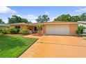 Charming single-story home with a lush green lawn and well-manicured landscaping in a desirable neighborhood at 1707 Hibiscus S Cir, Oldsmar, FL 34677