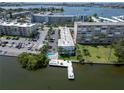 Gorgeous aerial view of the waterfront condo building, pool, boat dock and surrounding neighborhood on a sunny day at 1859 Shore S Dr # 202, South Pasadena, FL 33707