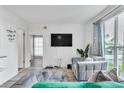 Bright living room with modern furniture, plush gray sofa and view of the natural light from the sliding glass doors at 1859 Shore S Dr # 202, South Pasadena, FL 33707