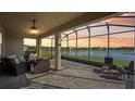 Enclosed outdoor patio with a ceiling fan and beautiful lake views at 19183 Coastal Shore Ter, Land O Lakes, FL 34638
