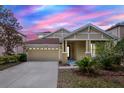 Inviting single-Gathering home featuring a beige exterior, well-manicured lawn, and two-car garage at 20106 Bending Creek Pl, Tampa, FL 33647
