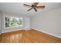Bright living room with wooden floors, ceiling fan and large windows with white shutters at 2073 Denmark St # 9, Clearwater, FL 33763