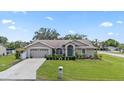 Inviting single-story home boasting a well-kept lawn, mature trees, and a two-car garage at 22852 Fern Ct, Land O Lakes, FL 34639
