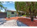 Quaint home with a covered porch, complemented by vibrant landscaping and a tranquil setting at 2303 E Osborne Ave, Tampa, FL 33610