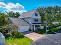 Beautiful two-story home with a manicured lawn, mature trees, and a spacious driveway leading to the garage at 2311 64Th Street W Ct, Bradenton, FL 34209