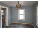 Dining room with blue walls, wood-look floors, window, and chandelier at 2326 Melrose S Ave, St Petersburg, FL 33712