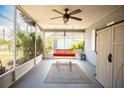 Inviting screened porch features a swing, ceiling fan, and views of the outdoors at 2403 E Osborne Ave, Tampa, FL 33610