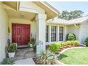 Inviting front entrance with red double doors, tiled porch, manicured landscaping and clear address numbers at 2517 Bucknell Dr, Valrico, FL 33596