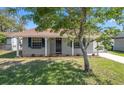 Inviting single-story home featuring lush lawn, landscaping, and a freshly painted facade at 2613 E 113Th Ave, Tampa, FL 33612