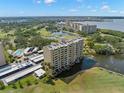 Scenic aerial view of condo community on the water, featuring a pond and lush landscaping at 2620 Cove Cay Dr # 704, Clearwater, FL 33760