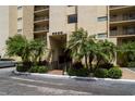 Attractive entrance to a condo building featuring palm trees and manicured landscaping at 2620 Cove Cay Dr # 704, Clearwater, FL 33760