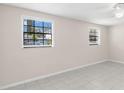 Bright, minimalist bedroom with tile floors, neutral paint and large windows with view of the outside at 2907 W Tyson Ave, Tampa, FL 33611