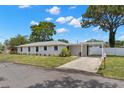 Well-manicured front yard and carport of this inviting single-story home; property number 2907 visible at 2907 W Tyson Ave, Tampa, FL 33611