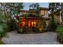 Eye-catching two-story home illuminated at night with stone driveway and tropical landscaping at 3112 W Wallcraft Ave, Tampa, FL 33611