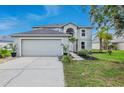 Inviting two-story home features a two-car garage, a manicured lawn and charming curb appeal at 31747 Loch Aline Dr, Wesley Chapel, FL 33545