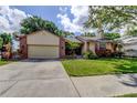 Charming single-story home with well-manicured lawn, mature landscaping, and inviting curb appeal at 3410 Briarwood Ln, Safety Harbor, FL 34695