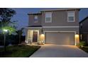 Charming two-story home with a two-car garage and inviting landscape lighting at 3446 Suncoast Plains Dr, Odessa, FL 33556