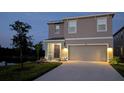 Inviting two-story home featuring a two-car garage and well-maintained landscape lighting at 3446 Suncoast Plains Dr, Odessa, FL 33556