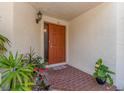 Warm and welcoming front entrance featuring a stylish door, brick walkway, and vibrant potted plants at 3455 Countryside Blvd # 101, Clearwater, FL 33761