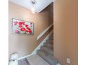 Cozy staircase with neutral tones, plush carpet, and a decorative light fixture, creating a welcoming ambiance at 3455 Countryside Blvd # 101, Clearwater, FL 33761