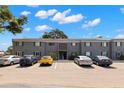 Well-maintained gray two-story condo building showcasing ample parking space under a partly cloudy sky at 4032 Cortez Dr # A, Tampa, FL 33614