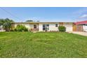 Charming home with a well-maintained lawn and stone accents, complemented by vibrant landscaping at 4099 Pompano Se Dr, St Petersburg, FL 33705