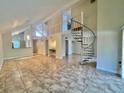 Spacious living room with high ceilings, tile floors, and a modern spiral staircase at 4117 Muriel Pl, Tampa, FL 33614