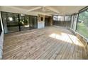 Large screened patio with wood flooring and stone accents, perfect for outdoor relaxation at 4117 Muriel Pl, Tampa, FL 33614