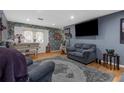 Cozy living room features hardwood floors, a comfortable couch, and a large television screen at 4499 Collins Rd, Spring Hill, FL 34606