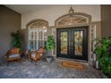 Charming front entryway features patterned glass double doors, elegant sidelights, and comfortable seating area at 4962 Turtle Creek Trl, Oldsmar, FL 34677
