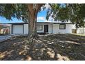 Charming single-story home featuring a white exterior, well-maintained garage, and inviting front porch at 5053 Lofton Dr, New Port Richey, FL 34652