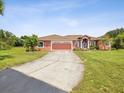 Charming single-story home boasts an attached garage and long driveaway at 5100 Lockhart Rd, Brooksville, FL 34602